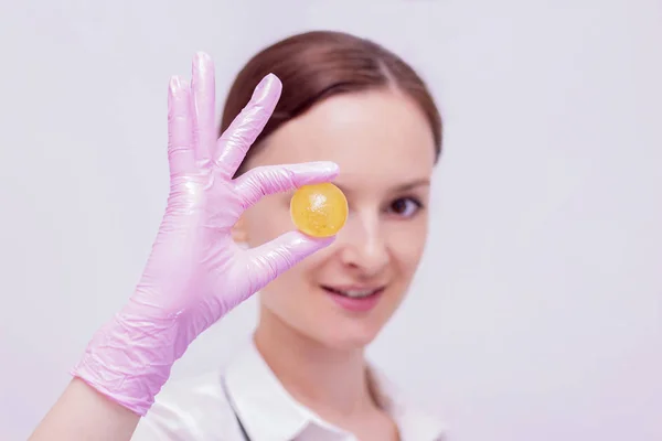 Depilation master girl holding a ball of sugar paste