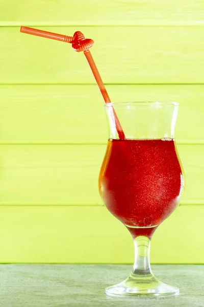 cocktail with glitter. Summer cooling red cocktail in glass beaker with a straw