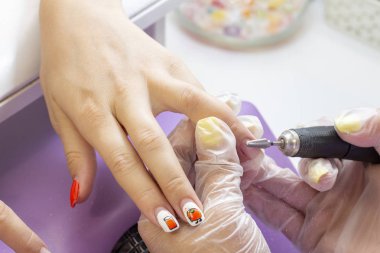 Shellac'ı kaldırıyoruz. hırdavat manikür. manikürcü bir manikür cihazı ile müşteriye tırnak plaka parlatma yapar