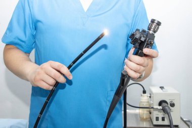 Hastanede endoskopi. Doktor, gastroskopiden önce endoskop tutuyor. Doktorun elinde endoskopi için alet.