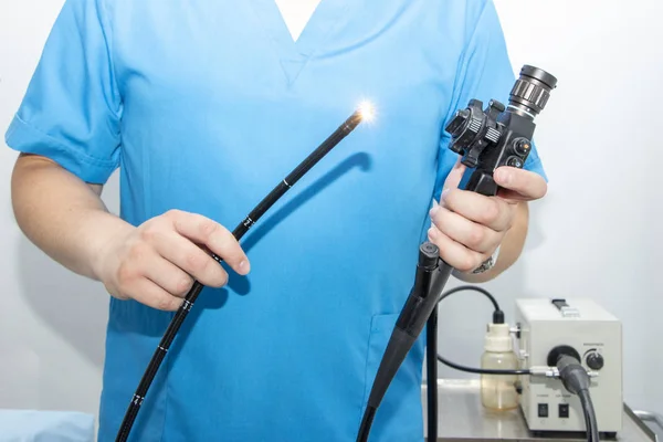 Hastanede endoskopi. Doktor, gastroskopiden önce endoskop tutuyor. Doktorun elinde endoskopi için alet.
