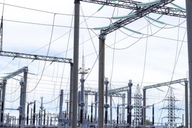 Güç Kulesi. Yüksek gerilim hatları ve güç direkleri. Şehir güç trafo, yakın çekim, yüksek gerilim kabloları ile transformatör. Yüksek elektrik direğine monte yüksek gerilim güç hatları bağlı