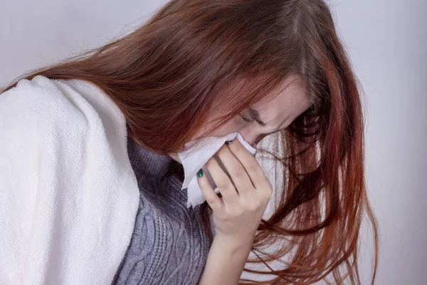 woman with sneezing nose blowing in tissue suffering winter cold and flu virus symptoms having medicines tablets and pills in illness and domestic health care concept