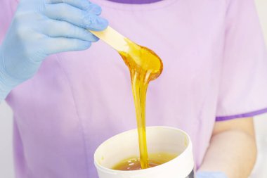 Cilt epilasyon için sıvı şeker. Yakın çekim. depilasyon ve güzellik kavramı - şeker macunu veya balmumu bal ahşap balmumu spatula çubukları ile saç kaldırma için