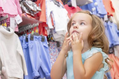 Alışveriş. Indirimler. küçük kız alışverişkolik. kız vitringüzel elbiseler ile mutlu. Alışveriş merkezi, alışveriş. Duyguları