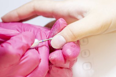 Tırnak levhasının öğütülmesi ve işlenmesi. Manikür ustası müşteriye manikür yapıyor. Jöle sürmeden önce oje sürüyorum. shellac