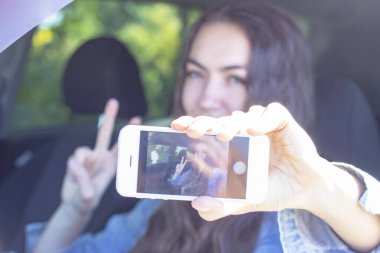 Şoför kız arabasını sürerken selfie çekiyor. Fotoğraftaki bulanık efekt.