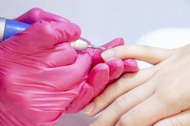 Tırnak levhasının öğütülmesi ve işlenmesi. Manikür ustası müşteriye manikür yapıyor. Jöle sürmeden önce oje sürüyorum. shellac