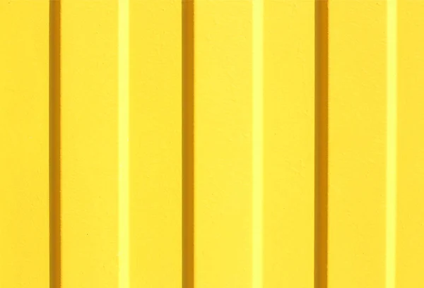 Texture of a profiled metal sheet painted in yellow color. shadow