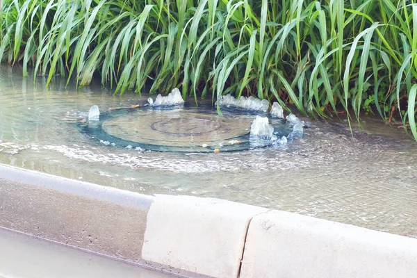 事故排水系统 水从下水道流过马路 水从下水道流过马路 下水道的事故 — 图库照片