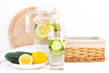 Sağlık hizmeti, fitness, sağlıklı beslenme konsepti. Taze soğuk limon salatalığı suyu, kokteyl, detoks içeceği, bardakta limonata ve bardakta. Bir tabakta salatalık ve limon