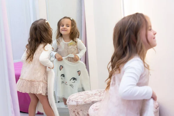 Girl trying on clothes in a fitting room in a clothing store.