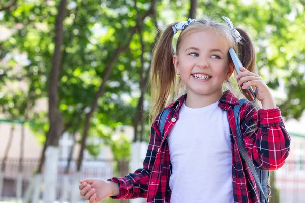 Gelukkig Schoolmeisje Met Een Rugzak Aan Telefoon Straat Een Wit — Stockfoto