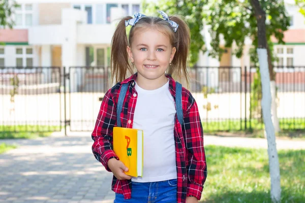 Gelukkig Schoolmeisje Met Een Leerboek Haar Handen Een Wit Shirt — Stockfoto