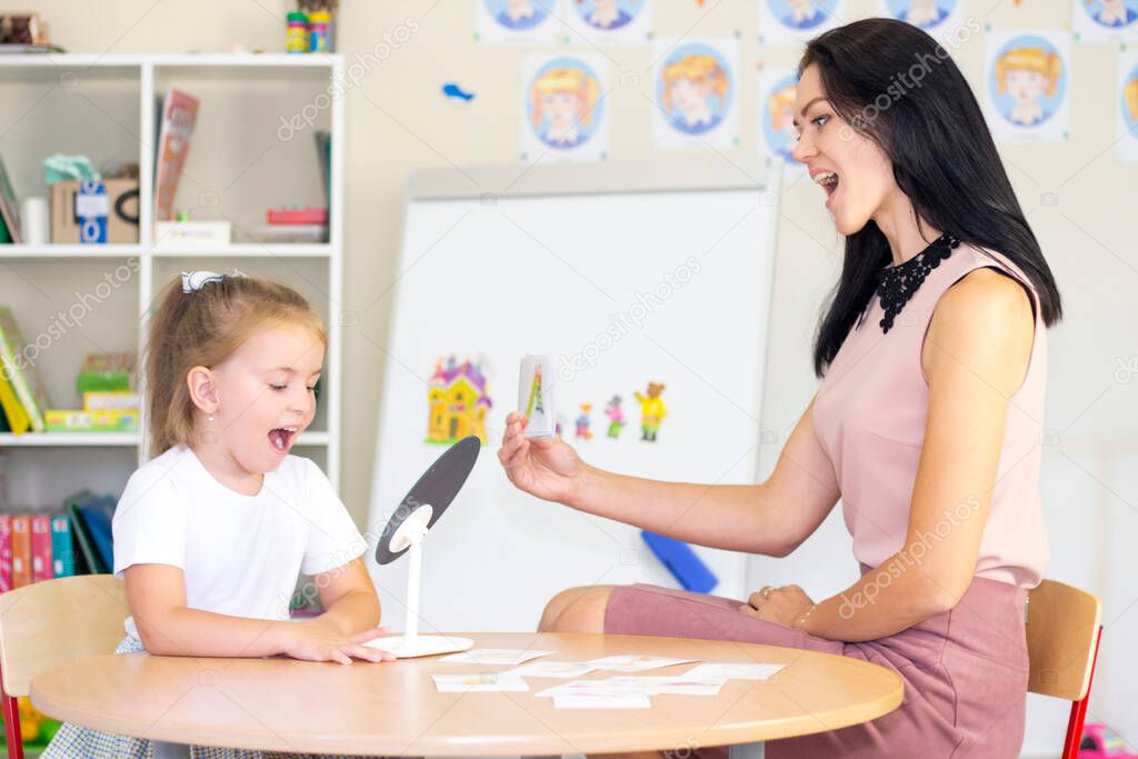 Speech therapist teaches the girl to say the letter. Mirror lesson
