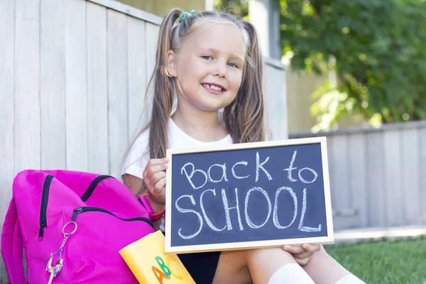 Schoolmeisje Zit Het Gras School Rugzak Houdt Een Bord Zijn — Stockfoto