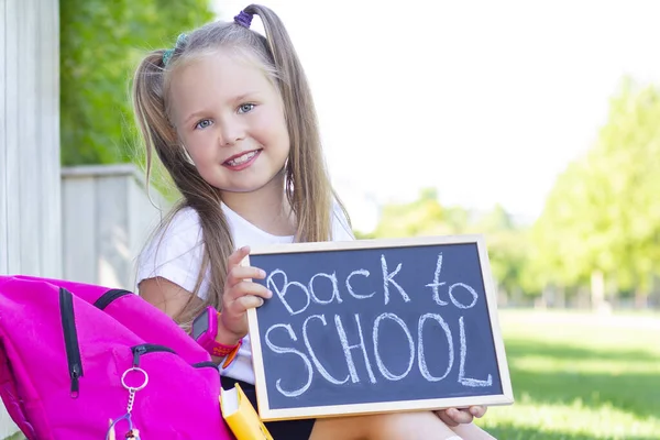 Colegiala Sienta Césped Mochila Escolar Sostiene Cartel Sus Manos Con — Foto de Stock