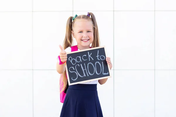 Schoolmeisje Staat Met Een Rugzak Een Bord Met Inscriptie Terug — Stockfoto