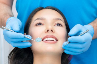 Diş hekimi hastaların dişlerini muayene eder..