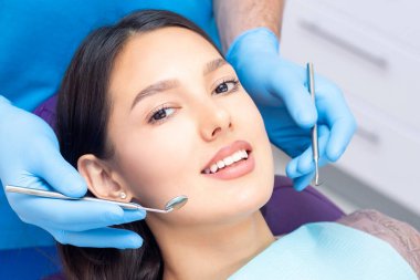 Diş hekimi hastaların dişlerini muayene eder..