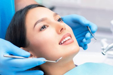 Diş hekimi hastaların dişlerini muayene eder..