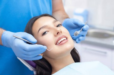 Diş hekimi hastaların dişlerini muayene eder..