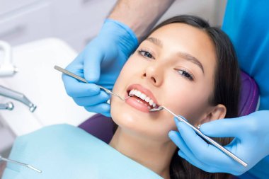 Diş hekimi hastaların dişlerini muayene eder..