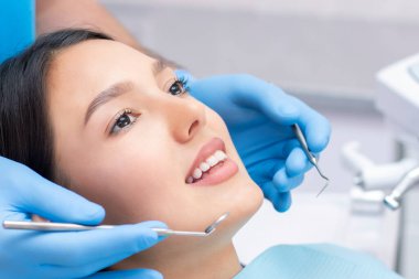 Diş hekimi hastaların dişlerini muayene eder..