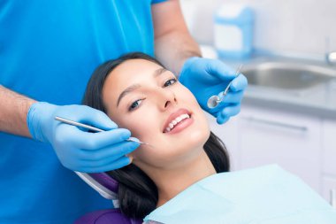 Diş hekimi hastaların dişlerini muayene eder..