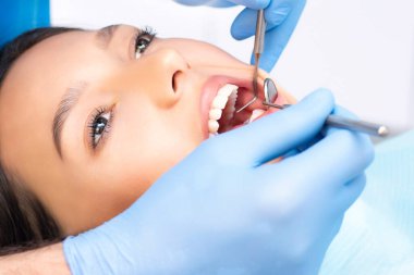 Diş hekimi hastaların dişlerini muayene eder..