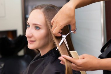 Kadın kuaförü, güzellik salonu. Profesyonel stilist kuaförde kadın saçı kesiyor.