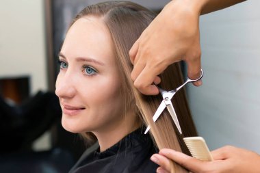 Kadın kuaförü, güzellik salonu. Profesyonel stilist kuaförde kadın saçı kesiyor.