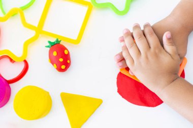 Beyaz bir masanın üzerinde renkli plastikçiden bebek heykelleri. Çocukların yaratıcılığı, eğitim oyunları, iyi motor becerileri.