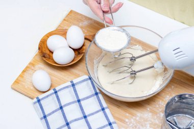 Ev yemeği konsepti. Kadın elleri un ahşap bir tahtanın üzerinde ev yapımı hamuru hazırlar. Yakın plan..