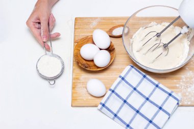 Ev yemeği konsepti. Kadın elleri un ahşap bir tahtanın üzerinde ev yapımı hamuru hazırlar. Yakın plan..