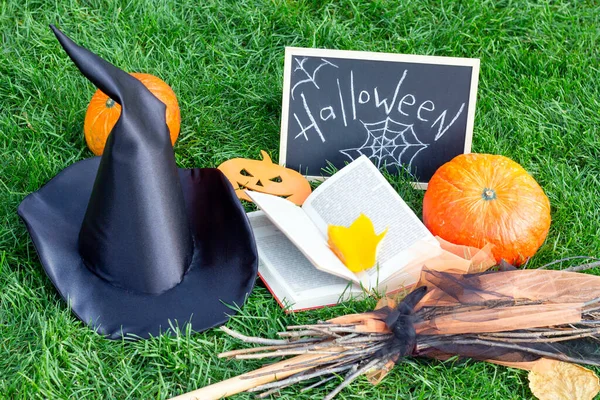 Halloween holiday. Pumpkins, Witch Hat, Spell Book, and Halloween Sign