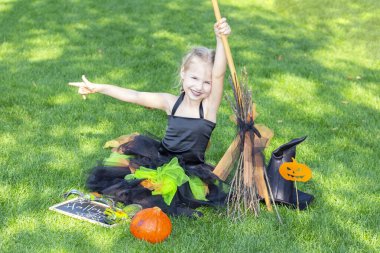 Cadılar Bayramı için cadı kostümü giymiş bir kız. Üzerinde 