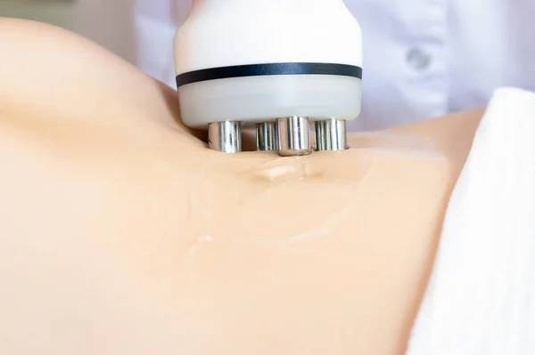 Donanım kozmetolojisi. Vücut bakımı. Spa tedavisi. Ultrasonik çürük vücuda şekil verme tedavisi. Bir kadın güzellik salonunda anti-selülit ve anti-yağ terapisi görüyor..