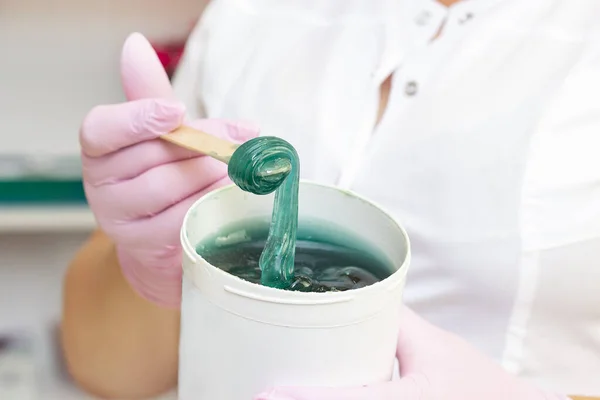 Liquid sugar for skin epilation. Close shot. cosmetologist holding a jar of sugar paste for depilation.