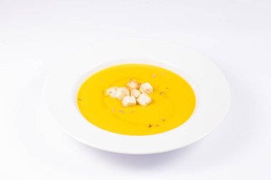 Beyaz arka planda ekmek ve yağ ile kabak krem çanak