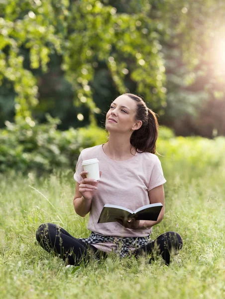 Młoda Kobieta Siedzi Trawie Parku Czytanie Książki Picia Kawy Cieszyć — Zdjęcie stockowe