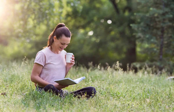 Hübsche Junge Frau Sitzt Auf Gras Park Und Liest Buch — Stockfoto