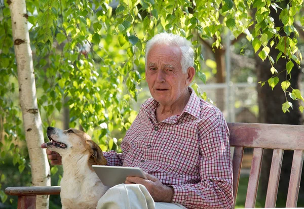 Triste Hombre Mayor Con Perro Sentado Banco Jardín Sosteniendo Tableta — Foto de Stock