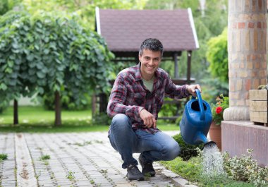 Çiçek Bahçe sulama yakışıklı adam. Bitki hemşirelik kavramı