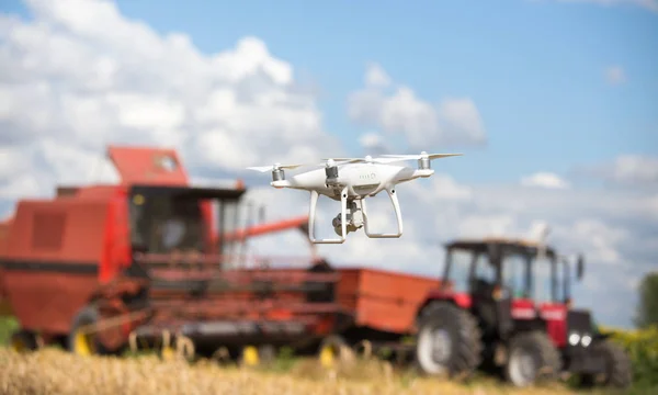 在早期的夏季 在拖拉机前飞行的无人机与向日葵田联合收割机 农业技术创新 — 图库照片