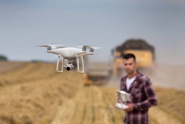 Buğday alan arka planda sürüş çiftçi ile hasat sırasında uçan dronun yakın çekim