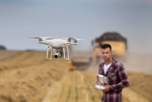 Zbliżenie Drone Latanie Nad Pole Pszenicy Podczas Zbiorów Rolnikiem Jazdy — Zdjęcie stockowe