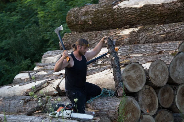 Junger Kräftiger Holzfäller Arbeitet Mit Axt Auf Holzstapel — Stockfoto