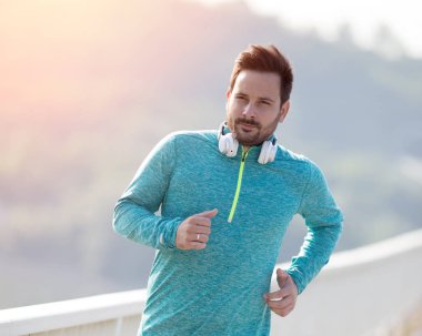 Köprüde çalışan memnun yakışıklı adam. Kentsel sabah koşu