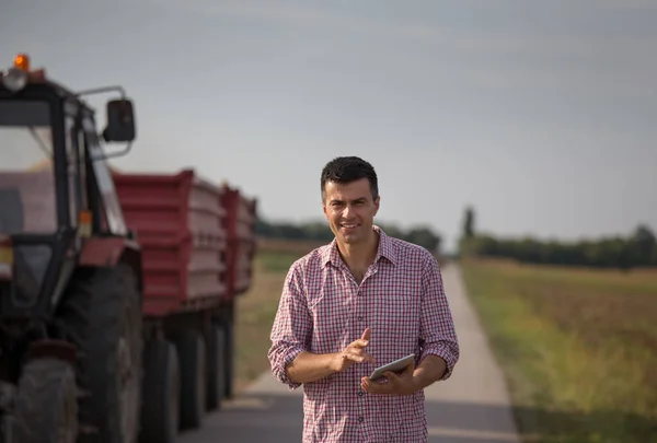 Schöner Bauer Mit Tablet Steht Vor Traktor Mit Anhänger Auf — Stockfoto